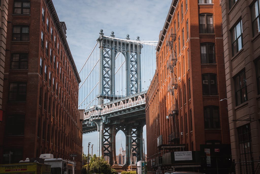 Stunning view of the Manhattan Bridge framed by red-brick buildings in New York City's DUMBO neighborhood.