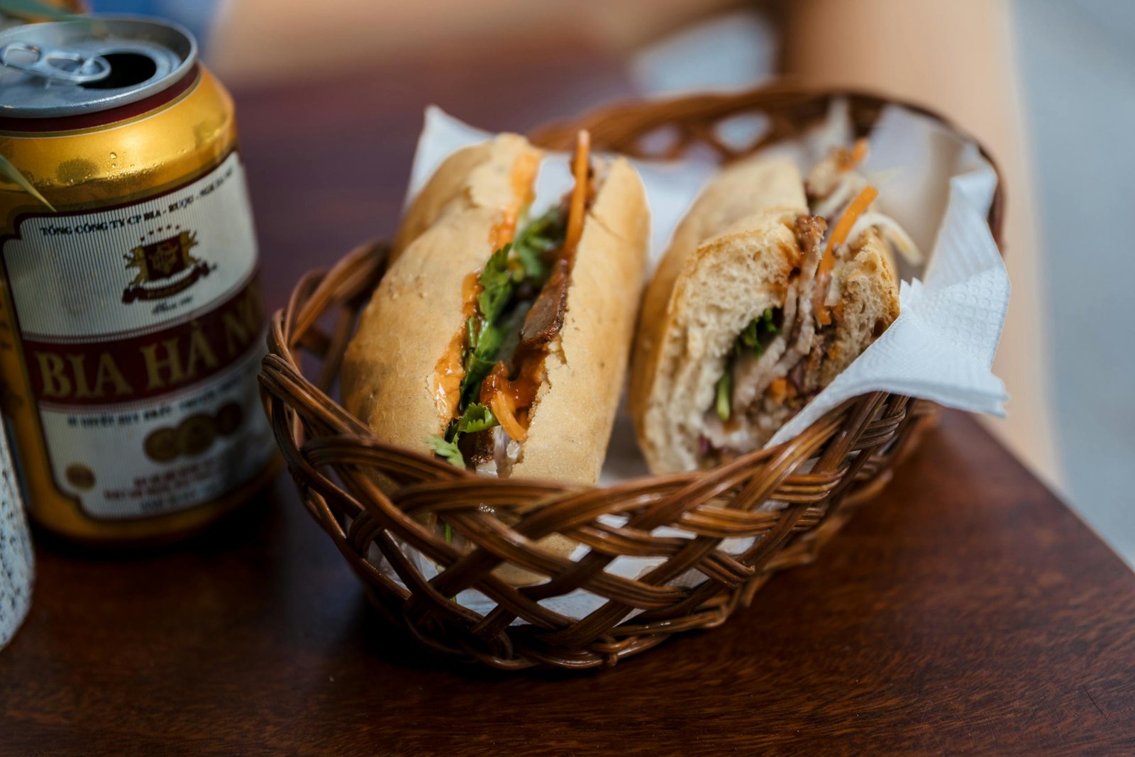 Savor a classic Vietnamese Banh Mi with a refreshing beer in Hanoi, Vietnam.