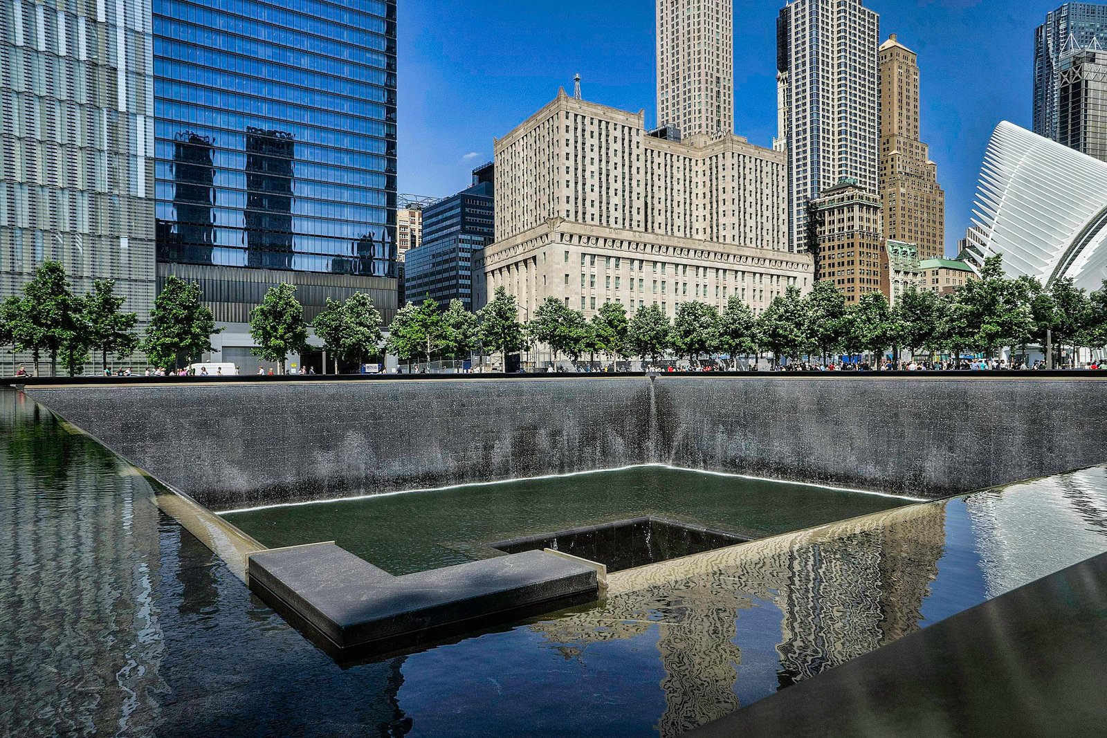 Stunning view of the New York City skyline with reflecting pool and vibrant urban architecture.